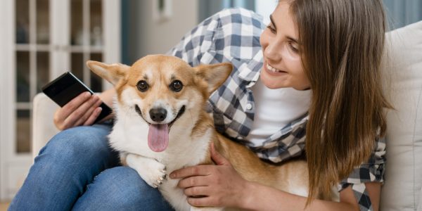 front-view-woman-holding-smartphone-dog